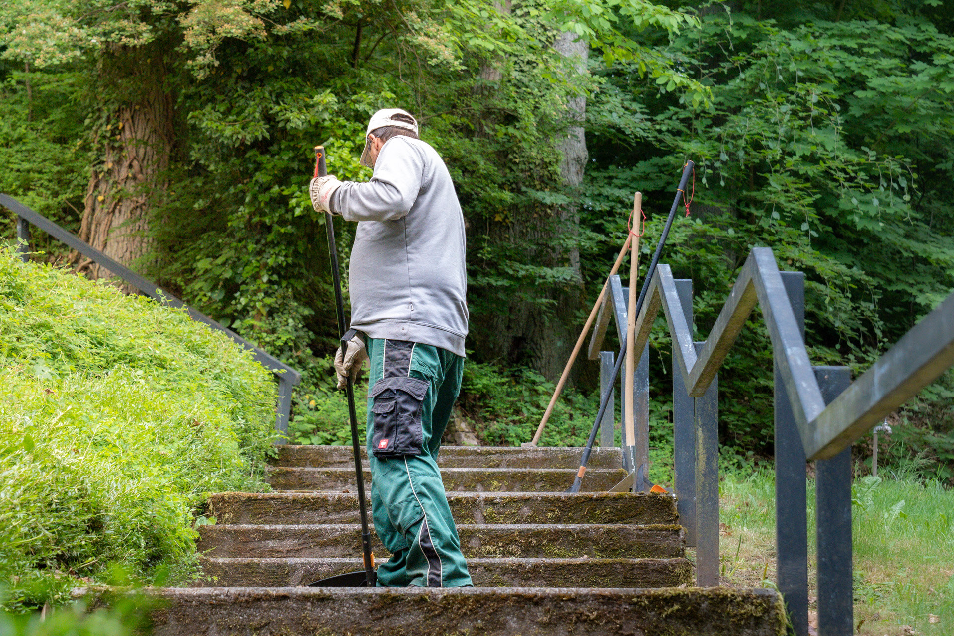 Ein Mann mit einem Rechen steht auf der Treppe
