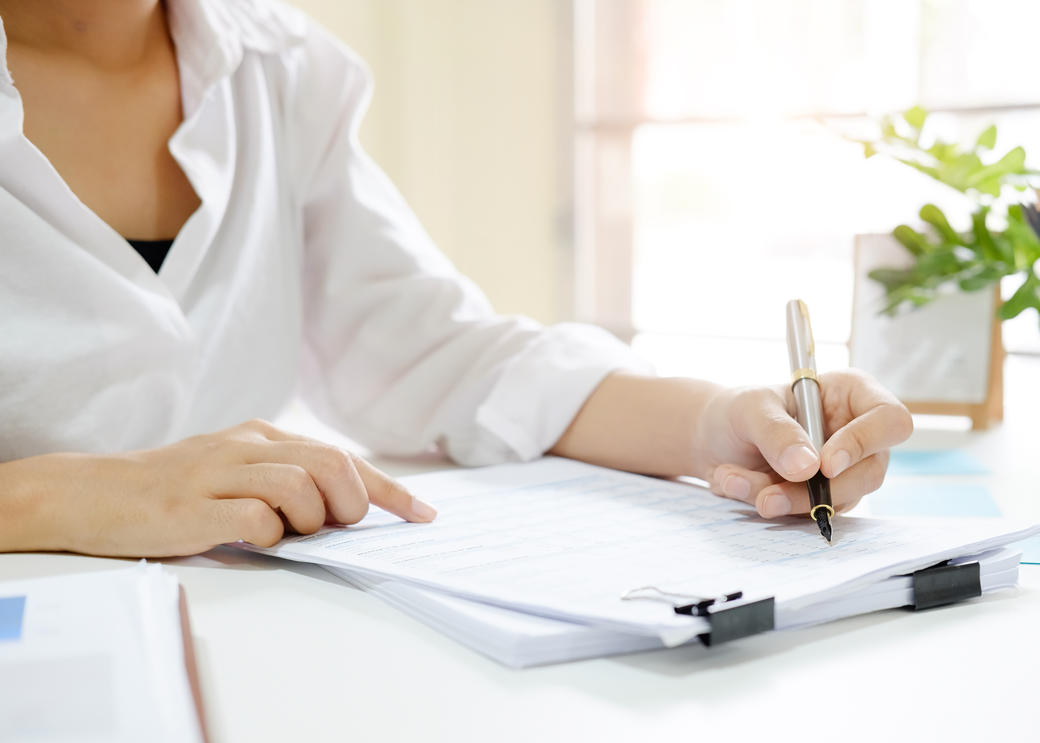 Eine Hand mit Füller, die ein Formular ausfüllt